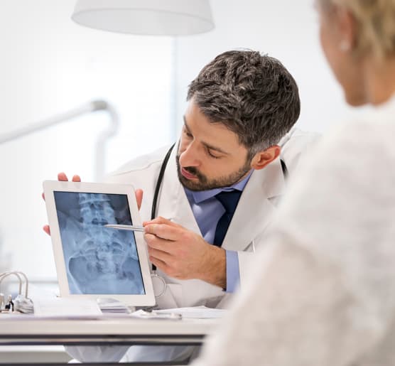 Hekim tablet üzerinde görüntüleme sonucunu hastaya gösteriyor